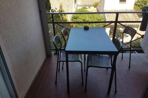 a blue table and chairs on a balcony at jolies studios avec piscines et parking privé 800m de la plage le grau du roi in Le Grau-du-Roi +12 photos