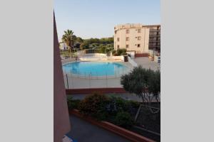 a view of a swimming pool from a building at jolies studios avec piscines et parking privé 800m de la plage le grau du roi in Le Grau-du-Roi