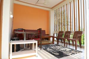 um quarto com mesas e cadeiras de madeira e uma janela em DIVINEHOMESTAY COMFORT SUITE em Tirupati