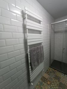 a white bathroom with a shower and a towel at Loft Carrión in Carrión de los Condes