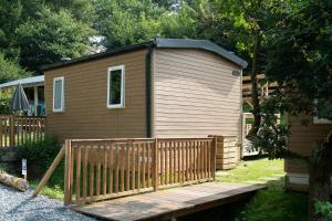 una piccola cabina con una terrazza in legno in un cortile di Tiny House a Enscherange