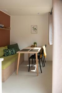 a dining room with a table and chairs and a couch at Tiny House in Enscherange