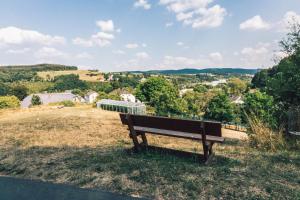 a wooden bench sitting on top of a field at Tiny House in Enscherange