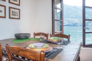 a dining room table with a view of the water at Apartments At the Pier Of Brienno - The House Of Travelers in Brienno