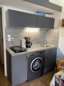 a kitchen with a washing machine and a sink at Maison Eden en village Naturiste in Leucate