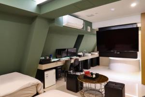 1 dormitorio con 1 cama y escritorio con ordenador en Shinchon Wol Hotel en Seúl