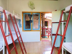 Zimmer mit 4 Etagenbetten und einem Eingang in der Unterkunft La Boheme Bajo in Labuan Bajo