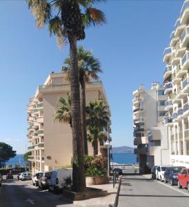 een straat met palmbomen voor een gebouw bij Appartement Vue Mer 75 m2 in Saint-Raphaël