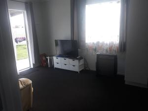 a living room with a television and a window at Comfortable 1 bedroom perfect for travelers or workers in Horotiu