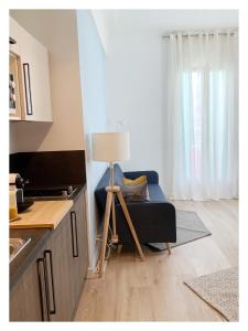 een woonkamer met een blauwe bank en een lamp bij Maison de Côte - Felice in Nice