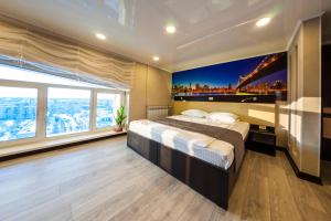 a bedroom with a large bed and a large window at Business-hall Panorama in Magnitogorsk