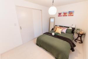 东京CuteFamilyHouse! 6minShinjuku 6minSta FreeParking Cozy,Bright KidsFree Under6yrs的一间卧室配有一张带绿毯的床