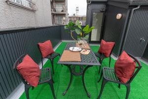 a table and chairs on a balcony with green grass at KidsFreeUnder12yrs!6minShinjuku 6minSta ParkingFree貸切一軒家 小学生以下無料 駐車場付き 新宿直通6分 代田橋駅徒歩6分 in Tokyo