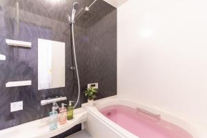 东京CuteFamilyHouse! 6minShinjuku 6minSta FreeParking Cozy,Bright KidsFree Under6yrs的一间带粉色浴缸和镜子的浴室 更多9张照片