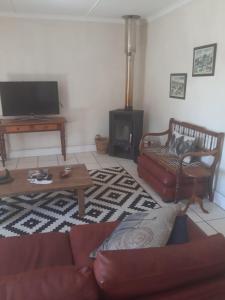 a living room with a couch and a coffee table at Olive Tree Cottage in Paternoster