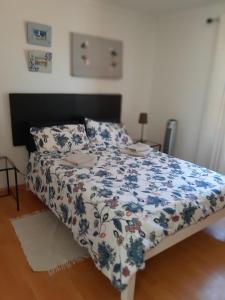 a bedroom with a bed with a blue and white comforter at Olive Tree Cottage in Paternoster