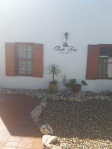 a house with plants in front of it at Olive Tree Cottage in Paternoster