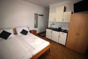 a bedroom with a large bed and a kitchen at Weinlandzimmer in Hengsberg