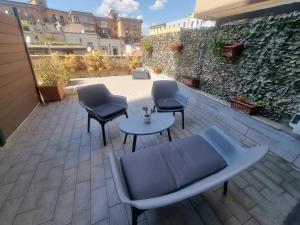 a patio with four chairs and a table and a wall at De Gasperi 55 in Naples