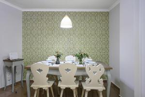 - une salle à manger avec une table et quatre chaises dans l'établissement Living4Malaga Soho Orangerie Deluxe, à Malaga