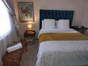 a bedroom with a large bed with a blue headboard at Richmond Hill Guest House in Port Elizabeth