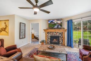 ein Wohnzimmer mit einem Kamin und einem Deckenventilator in der Unterkunft Villas 1425 condo in Steamboat Springs