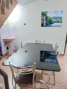 une table à manger avec des chaises et un tableau mural dans l'établissement 7TH HEAVEN Kannur, à Chakkarakkal