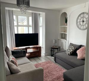 a living room with a couch and a flat screen tv at Luxury stay in the heart of Porthcawl in Porthcawl