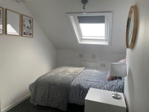 a small bedroom with a bed and a window at Luxury stay in the heart of Porthcawl in Porthcawl