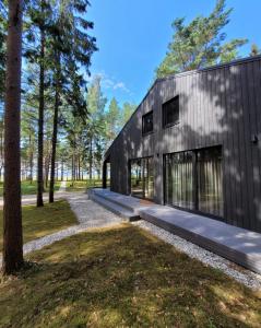 a modern house with a black facade at Beach House Trimpas in Unģeni