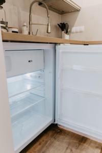 um frigorífico branco com a porta aberta numa cozinha em SK Apartments - Sandwood em Gelsenkirchen