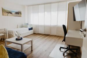 uma pequena sala de estar com uma cama e uma secretária em SK Apartments - Sandwood em Gelsenkirchen