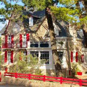 une maison avec une clôture rouge devant elle dans l'établissement Hôtel Lutétia & Spa, à La Baule