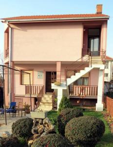 una casa con escaleras y arbustos delante de ella en Villa Majda en Peštani