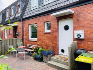 a brick house with a white door and a patio at Nordlys - Local & Style in Westerland