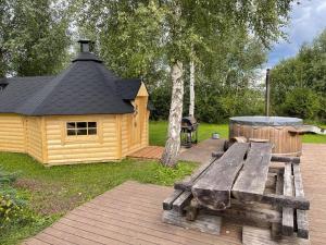 a wooden picnic table in front of a cabin at Beautiful private cabin near Tartu in Külitse