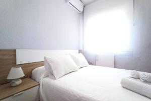 a bedroom with a white bed and a window at Lux Buenavista in Toledo +15 photos