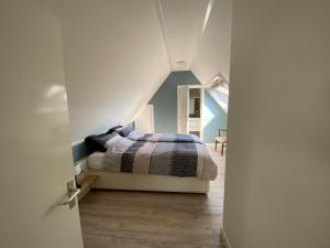 a bedroom with a bed in a attic at 't Klompenhuuske in Rossum