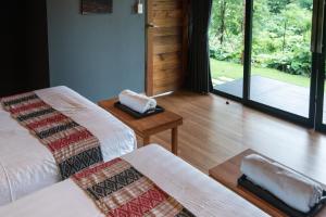 Habitación con 2 camas y puerta a un jardín en Huaysompoi Valley Nan, en Nan