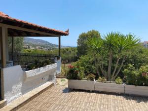 a house with a patio with plants and trees at La casa de PortoRafti in Porto Rafti