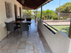 a patio with a wooden table and chairs on it at La casa de PortoRafti in Porto Rafti