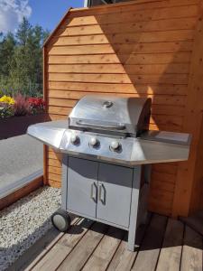 a barbecue grill sitting on a wooden deck next to a building at Apartment Serlesblick in Ellbögen