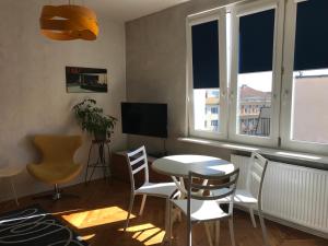 a living room with a table and chairs and a television at Apartament w centrum Gdyni in Gdynia