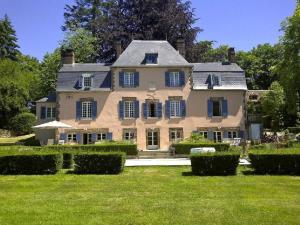 a large house with a lawn in front of it at Le Charme in Mézilles