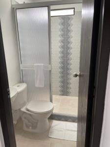 a bathroom with a toilet and a glass shower at APARTAESTUDIO Parque Olaya Pereira in Pereira