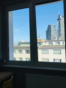 two windows in a room with a view of a building at Apartament w centrum Gdyni in Gdynia