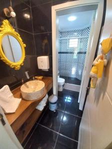 uma casa de banho com um lavatório, um espelho e um WC. em Casa Ari Candiago Gramado em Gramado