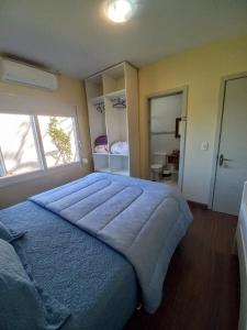 a bedroom with a large blue bed with a window at Casa Ari Candiago Gramado in Gramado