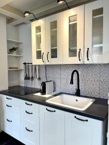 uma cozinha com armários brancos e um lavatório em COZY LOFT MARINA VIEW em Savona