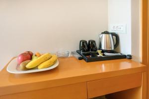 a plate of fruit on a counter with a coffee maker at Maritina Hotel in Kos